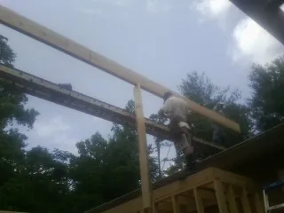 Carpenter setting a ridge beam over a new addition frame — Ice Dam Removal by Roofing Brothers in Sugarcreek