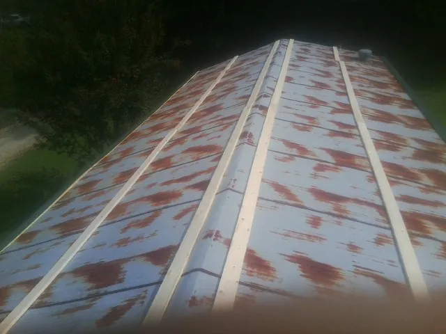 Rusted metal roof panels with new wood purlins before replacement — Storm Damage Roof Repair in Sugarcreek by Roofing Brothers