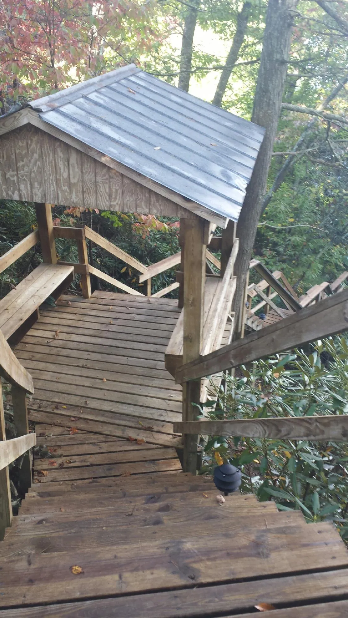 Metal roofed shelter over wooden steps on a wooded walkway — Skylight Repair & Installation work by our crew in Sugarcreek