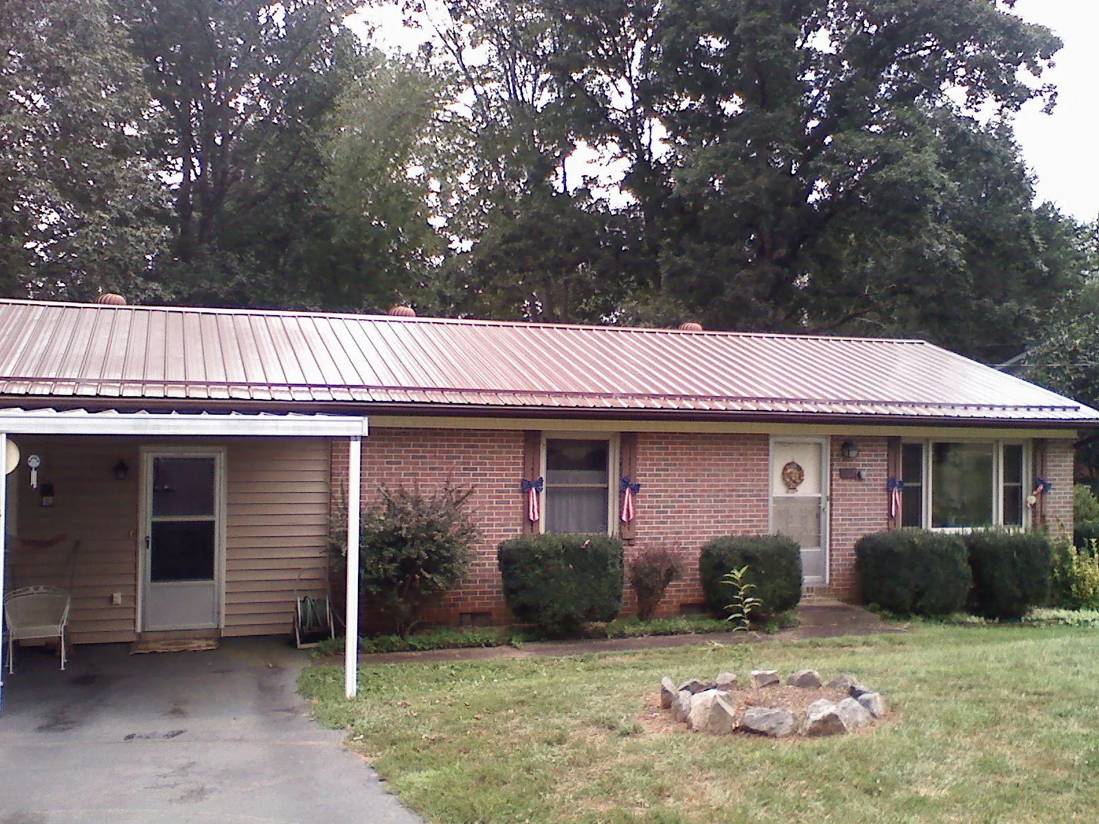 Bronze metal roof and carport on a brick ranch home — Roof Repair work by our crew in Sugarcreek