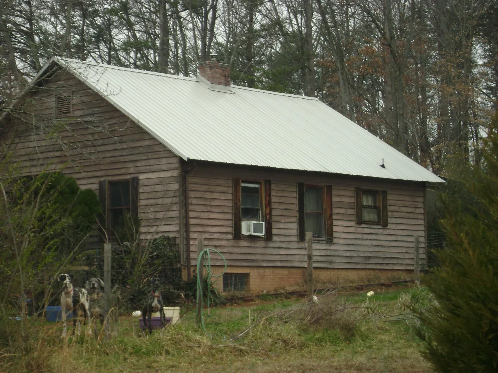 White metal roof on an old wood sided farmhouse, from a Metal Roof Installation job in Sugarcreek